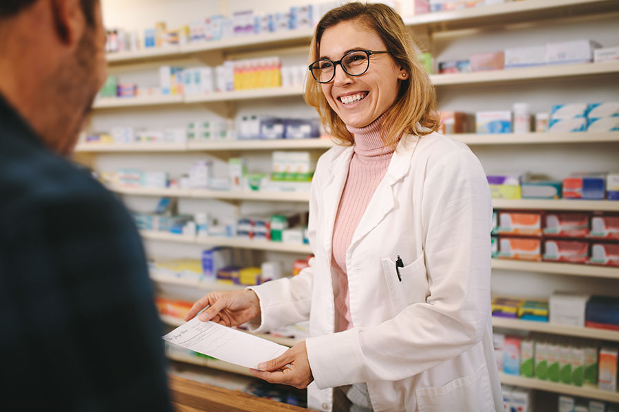 Pharmacy Insurance Network - Helpful Pharmacist Dealing with a Customer